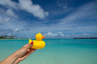 Yellow duck on the tropical beach. Concept travel and vacation