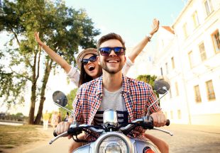 Couple in love riding a motorbike , Handsome guy and young sexy woman travel . Young riders  enjoying themselves on trip. Adventure and vacations concept.